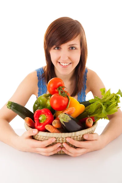 Een jonge vrouw met een mand vol van groenten — Stockfoto