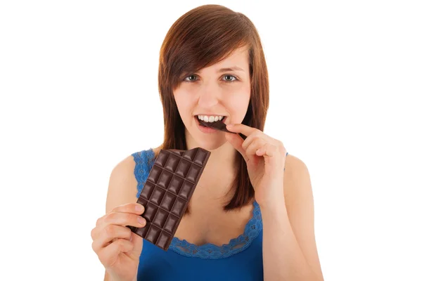 Den unga kvinnan äter en bar av choklad — Stockfoto