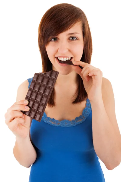 La joven está comiendo una barra de chocolate. — Foto de Stock