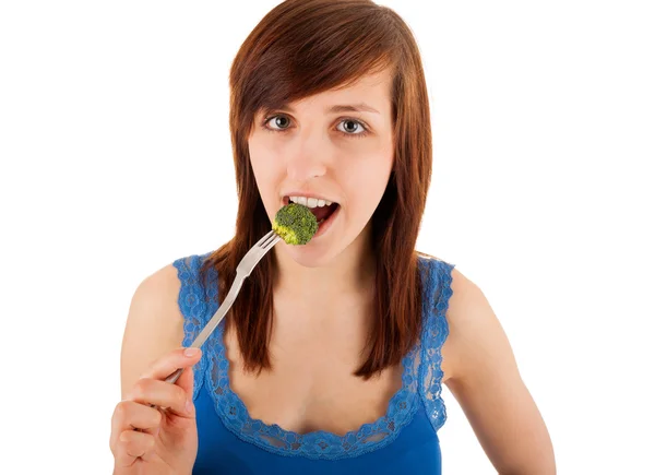 Młoda kobieta z kawałkiem brokuły na jej widelec — Zdjęcie stockowe