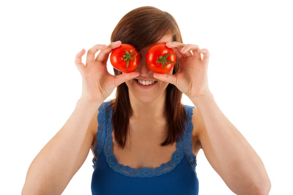 Den unga kvinnan täcker ögonen med tomater — Stockfoto