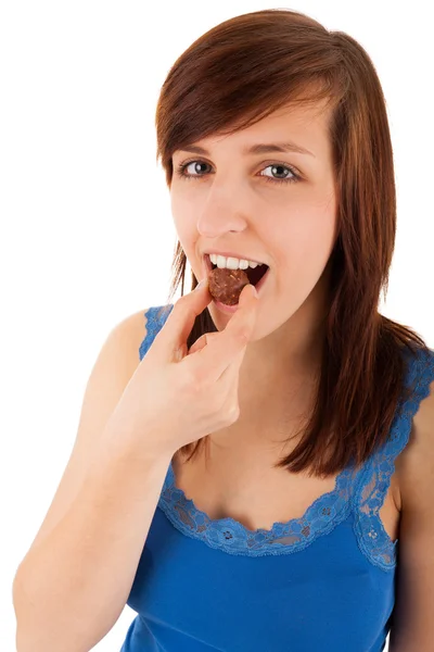 The young woman is eating chocolate with pleasure — Stock Photo, Image