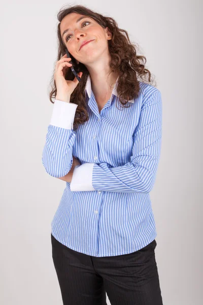 A jovem mulher de negócios está ao telefone com seu telefone celular — Fotografia de Stock
