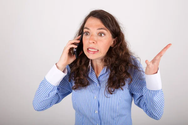 A jovem mulher de negócios está ao telefone com seu telefone celular — Fotografia de Stock