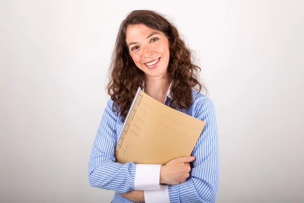 De jonge zakenvrouw houdt een bestand in haar handen — Stockfoto