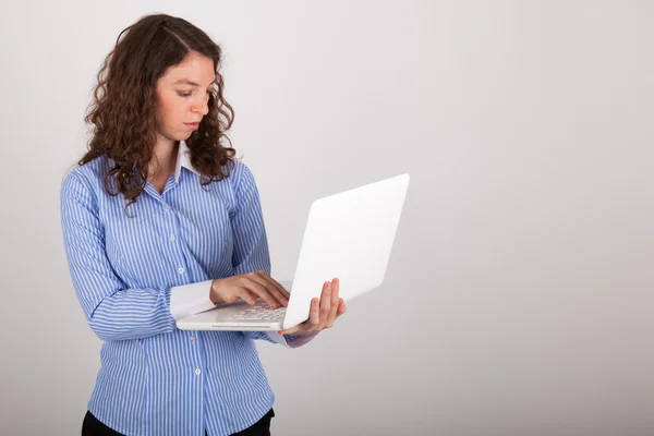 De jonge zakenvrouw werkt met haar laptop — Stockfoto