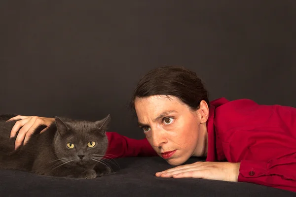The young woman is cuddling with her cat — Stock Photo, Image