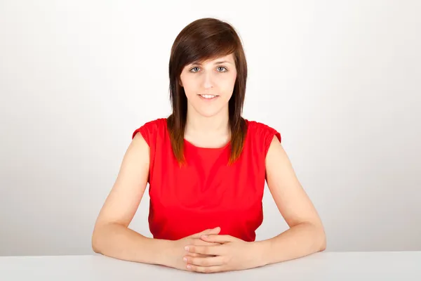 De jonge vrouw is gelukkig zitten aan de tafel. — Stockfoto