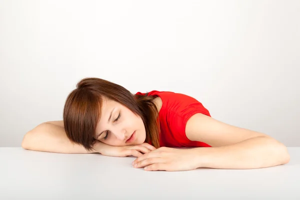 La joven está enojada sentada a la mesa. —  Fotos de Stock