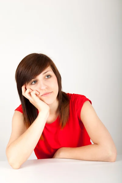 La joven está aburrido en una mesa — Stockfoto