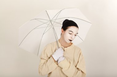 Beyaz bir şemsiye elinde tutan palyaço