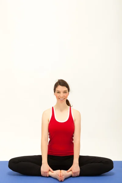 The young woman is exercising on a mat — Stock Photo, Image