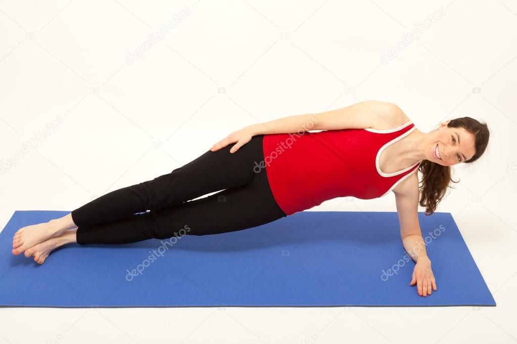 The young woman is exercising on a mat