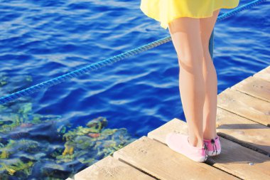Denizde ahşap köprü üstünde sokulgan feet