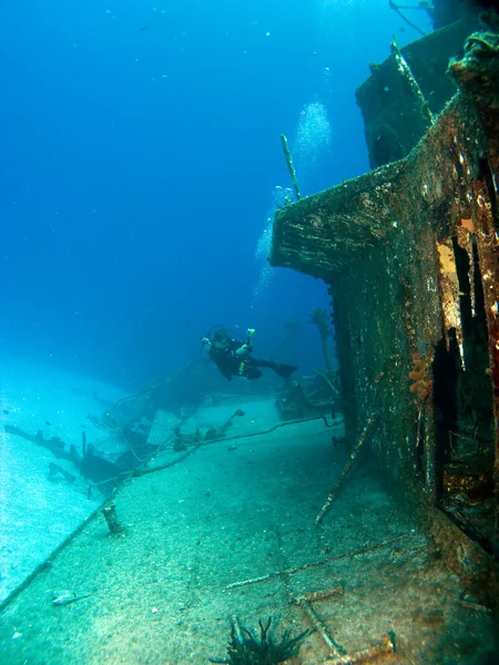 Fotógrafo submarino tomando fotos de un barco hundido — Foto de Stock