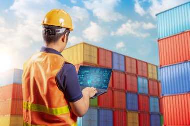 Engineer or asian worker work with computer notebook at container terminal