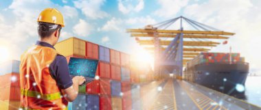 Mühendis veya Asyalı işçiler konteynır terminalinde bilgisayar defteri ile çalışırlar