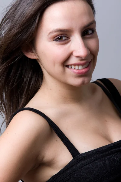 Closeup portrait of a beautiful young woman smiling, against a g — Stock Photo, Image