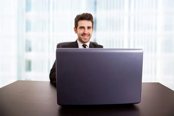 Joven hombre de negocios que trabaja con es portátil en la oficina — Foto de Stock