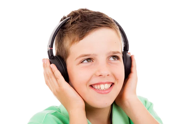 Smiling little boy listening to music on headphones against whit — Stock Photo, Image