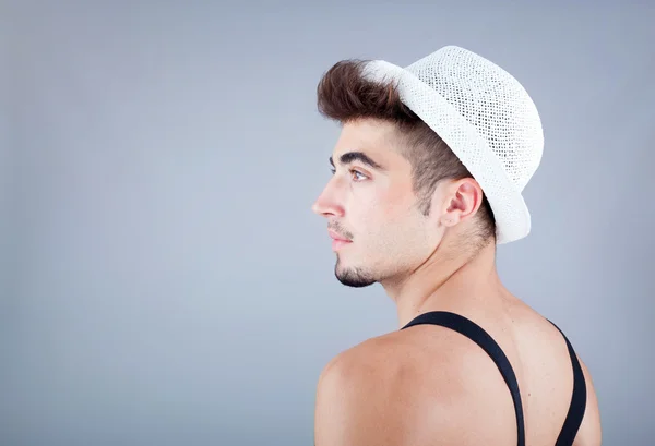 Portrait d'un beau jeune homme au chapeau sur fond gris — Photo