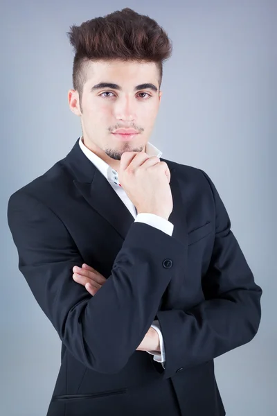 Portrait of a handsome young business man on grey background — Stock Photo, Image