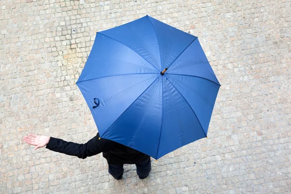 Homem de negócios escondido sob guarda-chuva e verificar se está chovendo — Fotografia de Stock