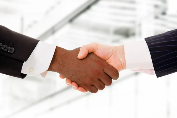 Business team shaking hands while in their office — Stock Photo, Image