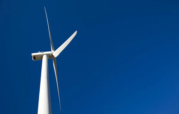 Molino de viento que genera electricidad en el cielo azul — Foto de Stock