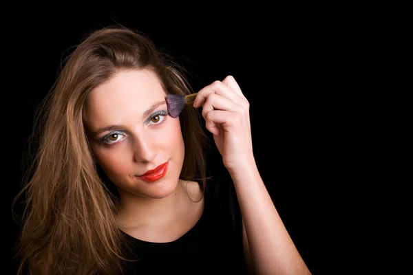 En ung kvinna med en makeup borste — Stockfoto