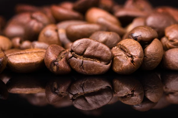 Montón de granos de café sobre fondo negro — Foto de Stock