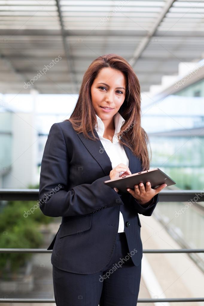 Smiling business woman using tablet PC at the office
