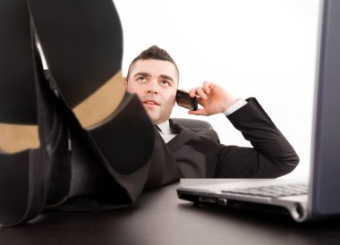 Ofis Masası rahatlatıcı ve cep telefonunuza konuşan genç iş adamı