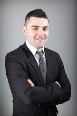 yakın çekim yakışıklı genç iş adamı üzerinde gri backg portresi