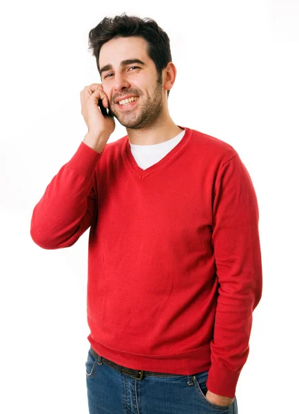 Sonriente joven hombre casual hablando por teléfono aislado en blanco — Foto de Stock