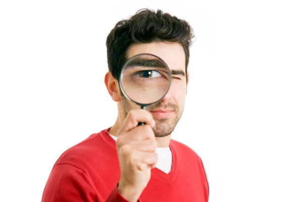 Young man looking through magnifying glass, isolated on white — Stock Photo, Image