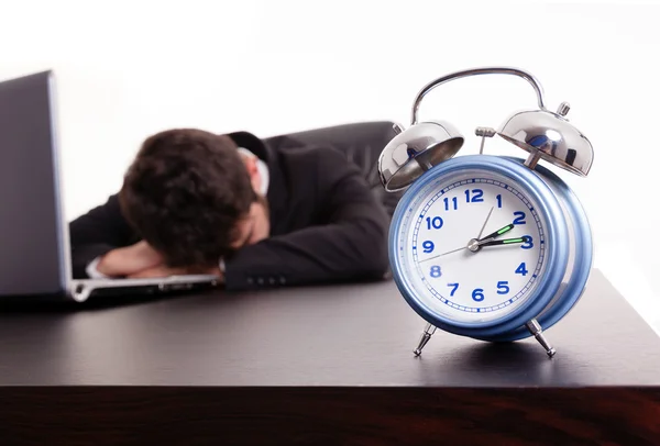 Uitgeput jonge zakenman slapen naast zijn laptop op de — Stockfoto