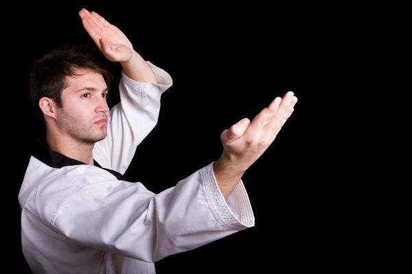 Jovem praticando artes marciais contra fundo preto — Fotografia de Stock