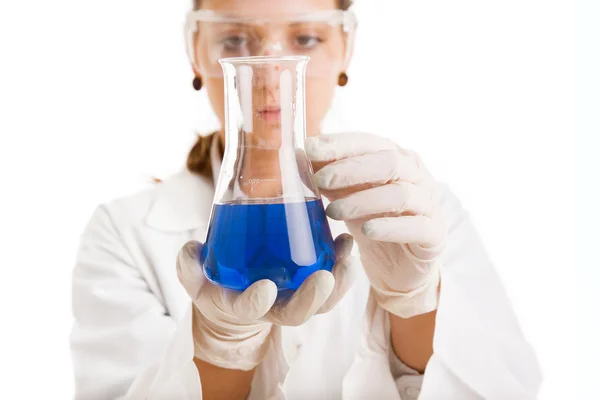 Female scientist looking at beaker of liquid — Stock Photo, Image