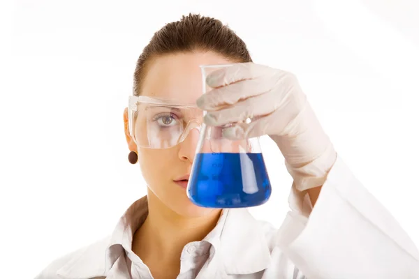 Female scientist with a beaker of liquid on white background — Stock Photo, Image