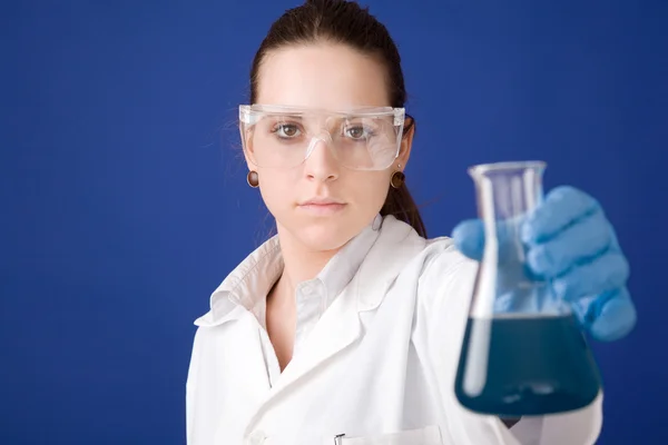 Young female researcher against blue background — Stock Photo, Image