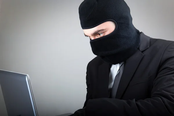 Computadora hacker en traje y corbata sobre fondo gris —  Fotos de Stock