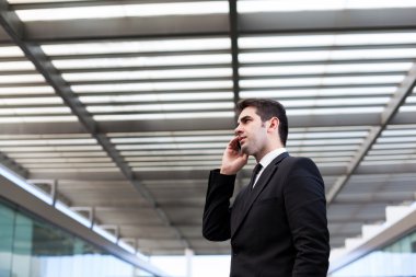 modern ofis cep telefonuyla konuşan başarılı genç iş adamı