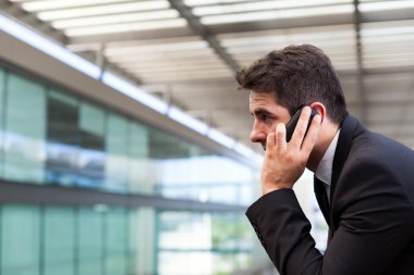 modern ofis cep telefonuyla konuşan başarılı genç iş adamı