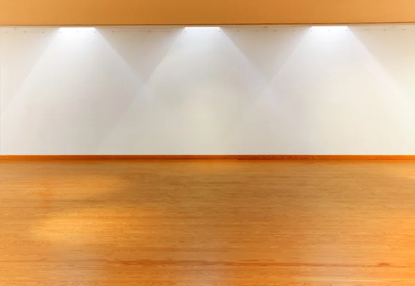 Pared blanca vacía con focos y suelo de madera — Foto de Stock