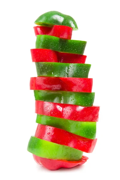 Em fatias de pimenta vermelha e verde sobre um fundo branco — Fotografia de Stock