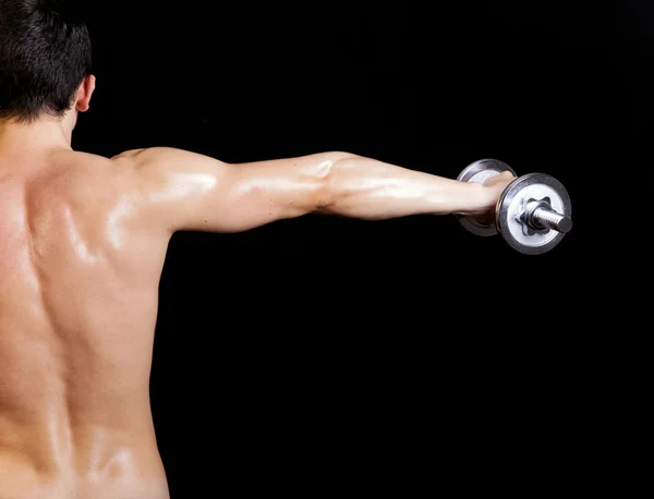 Egy fiatal férfi a feladatot a súlyzó ellen hátulnézete — Stock Fotó