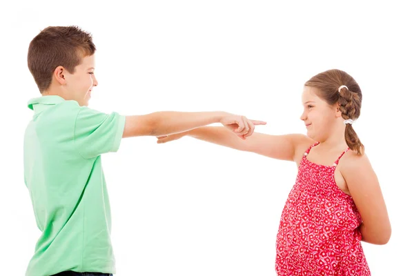 Zwei lächelnde Kinder, die sich gegenseitig zeigen, isoliert auf weißem Rücken — Stockfoto