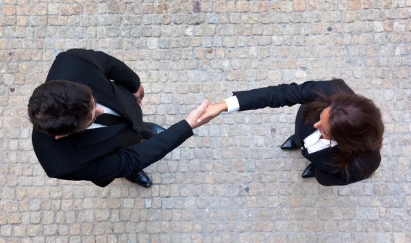 Aperto de mão entre empresário e empresária — Fotografia de Stock