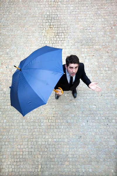 Hombre de negocios joven comprobando si está lloviendo —  Fotos de Stock